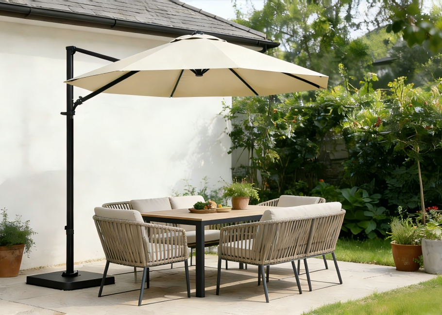 Outdoor patio set with table, chairs, and cantilever umbrella in a garden setting.