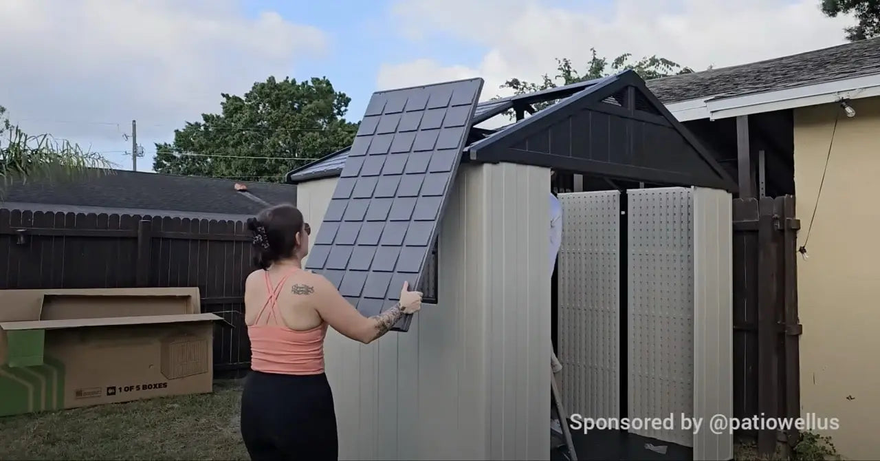 A lady assembling the roof of a 8x6 plastic storage shed.