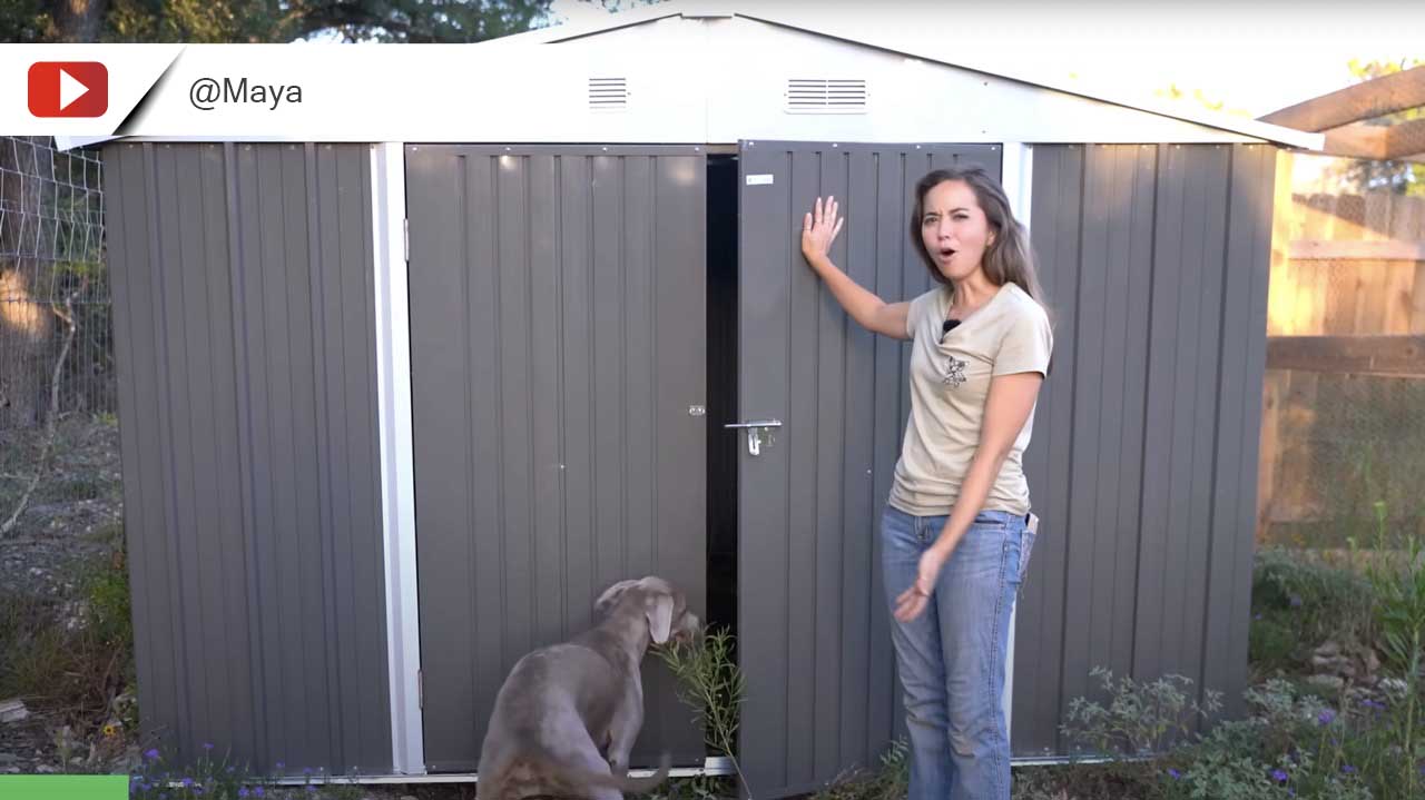 A woman and her dog standing in front of the 10x10 metal storage shed, leaning against the door.