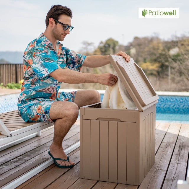 A man is opening the lid of a outdoor storage box by the poolside