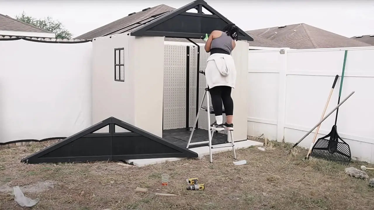 a lady is assembling the 8x6 plastic storage shed