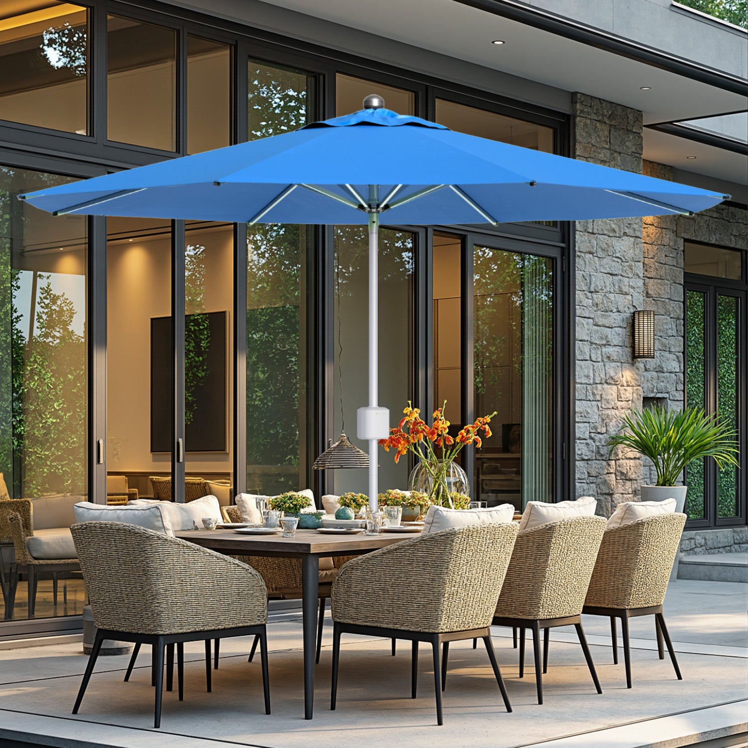 Outdoor patio set with a blue umbrella, table, and chairs in front of a modern house.